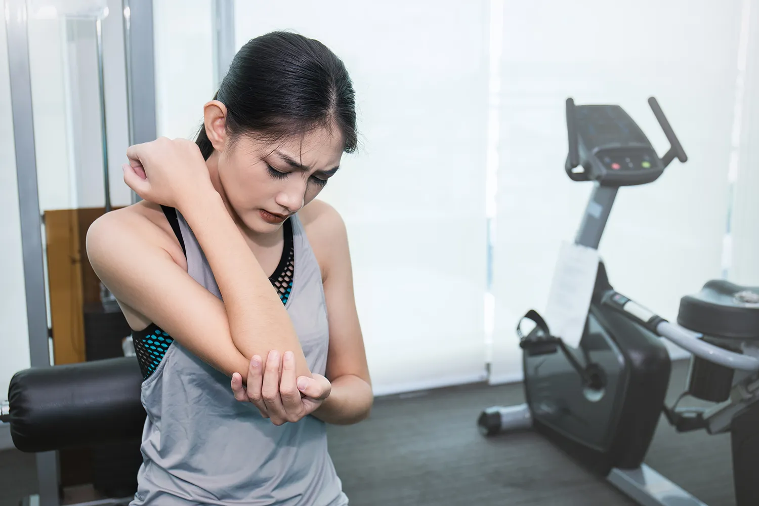 young woman holding her arm pain due to exercising