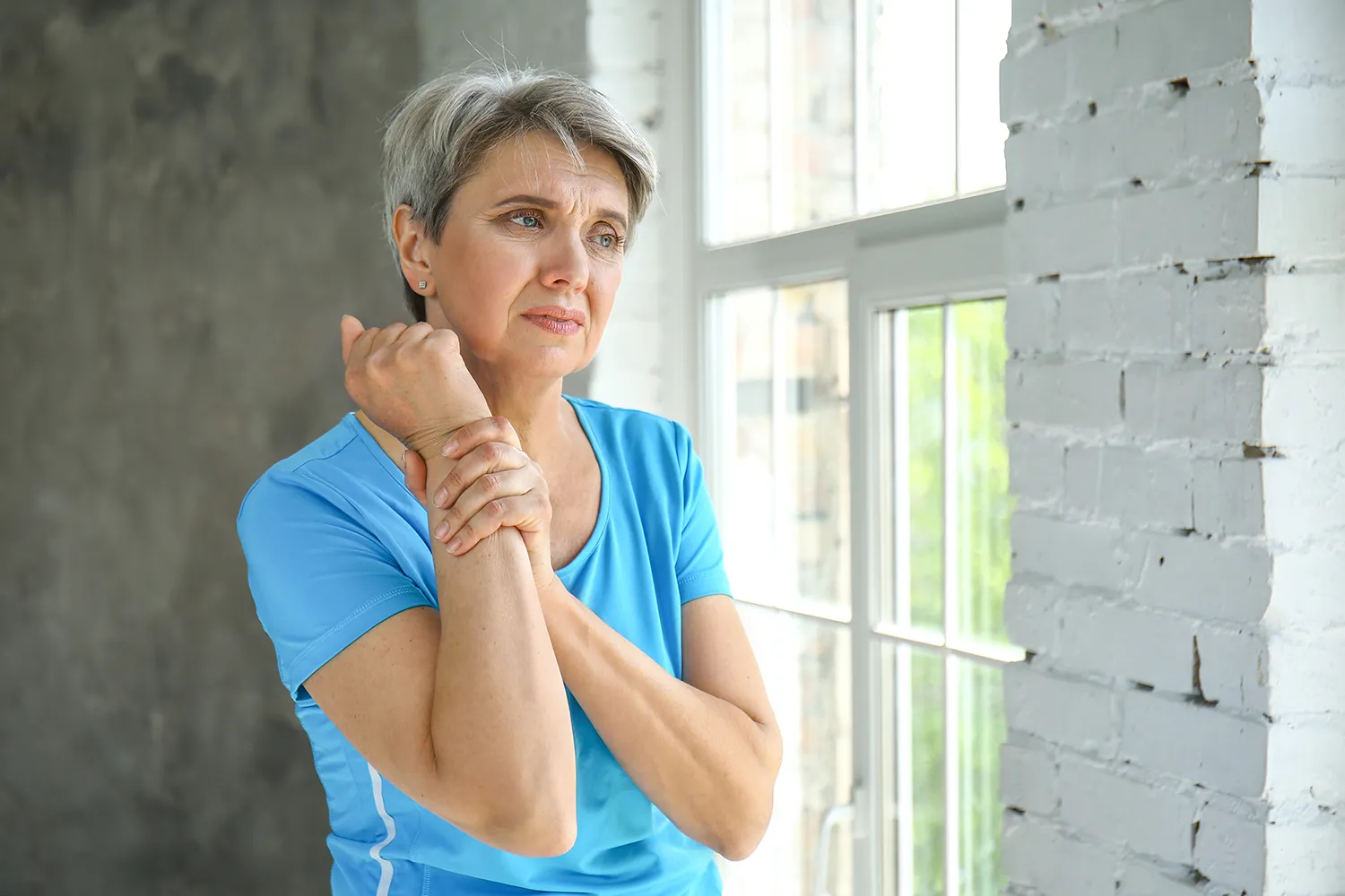 woman holding her arm due to pain