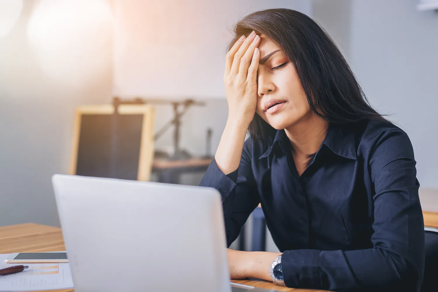 young woman having headache pain while working on laptop